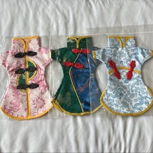 Set of three brocade Wine Bottle Dresses in pink, green, and blue.